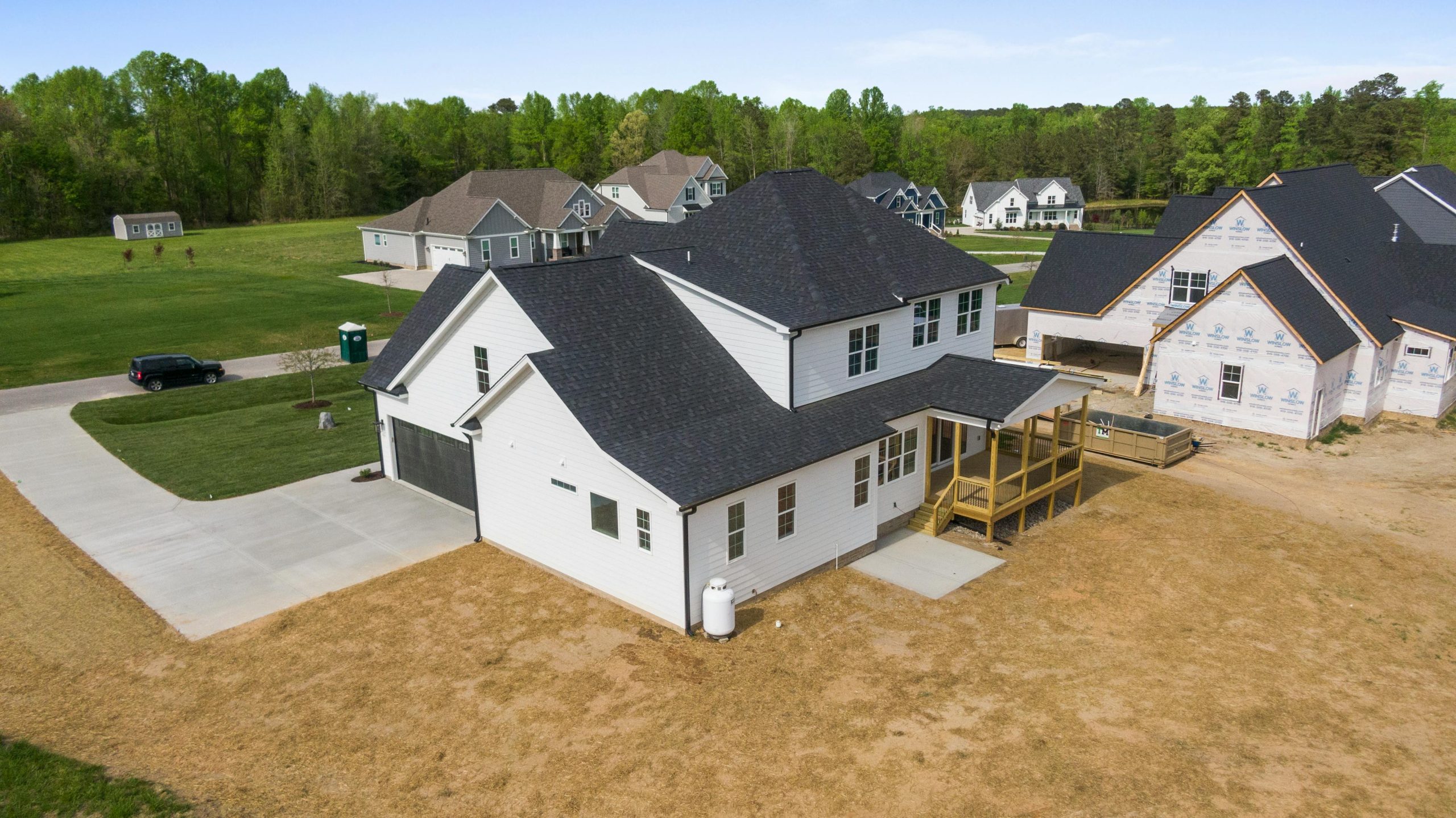 Boost Your Home’s Curb Appeal with a New Roof Aerial view of newly constructed homes in a suburban neighborhood in Youngsville, NC, surrounded by greenery.